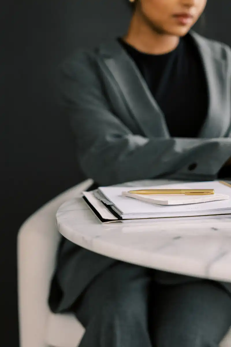 Editorial shot of notebooks on table where woman is working