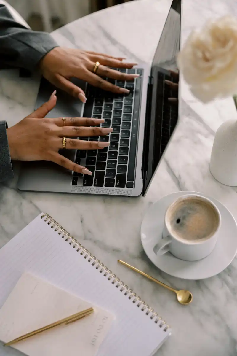 Woman working on her laptop while sitting at her desk