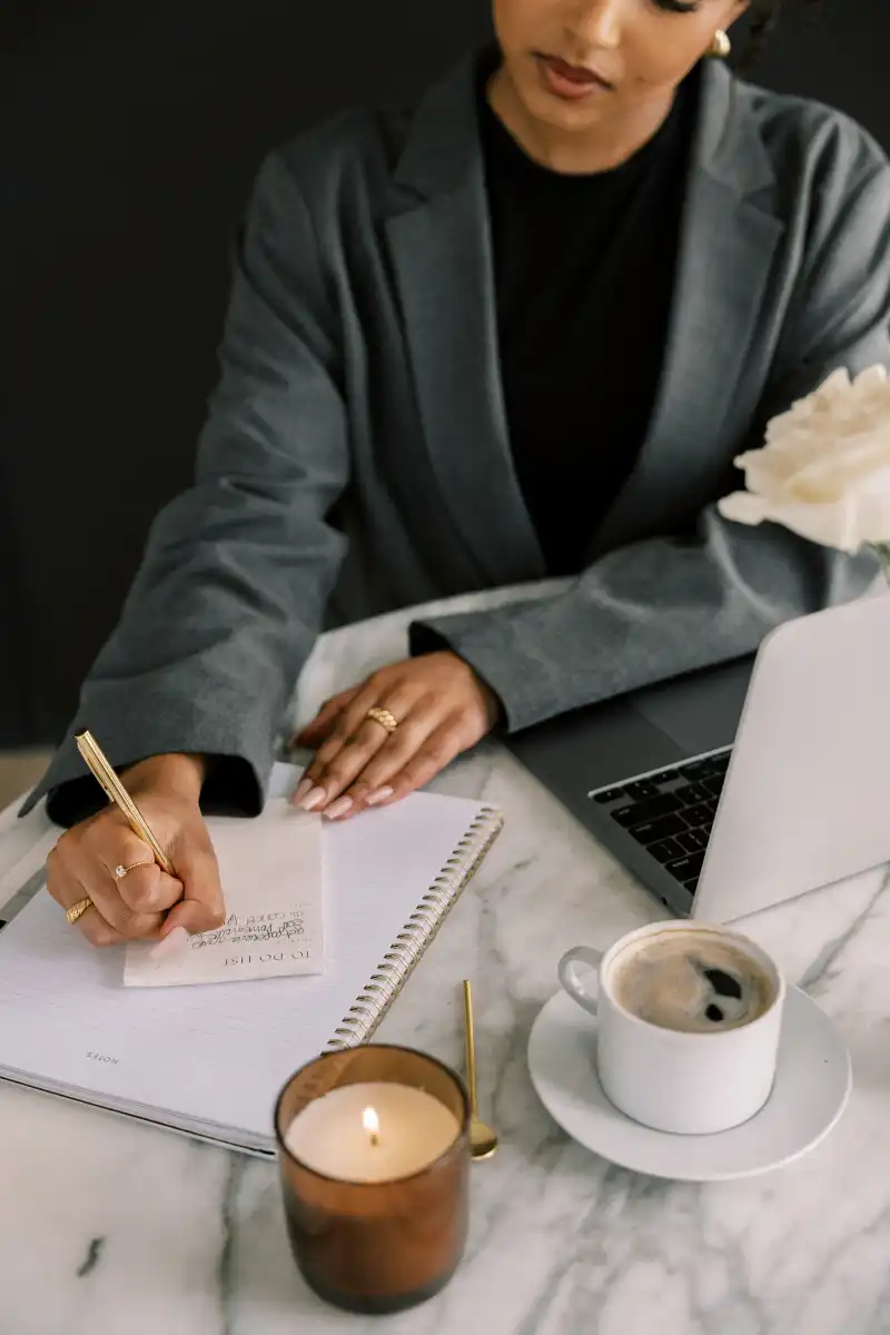 Woman working at her desk, writing on her notepad